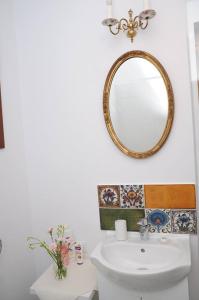 een badkamer met een wastafel en een spiegel aan de muur bij Sophie Apartment in Oradea