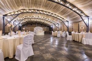 a banquet hall with white tables and white chairs at Ulitkino Park Hotel in Rayki