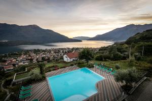 a swimming pool with a view of a town and a lake at Residence La Collina in Vercana