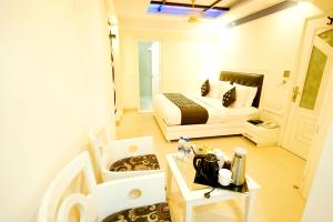 Un pequeño dormitorio con una cama y una mesa con sidra de mesa en THE SINGH EMPIRE, New Delhi, en Nueva Delhi