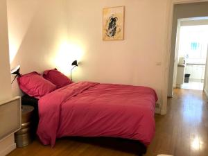 ein Schlafzimmer mit einem großen Bett mit roter Bettwäsche in der Unterkunft L'appartement Magdebourg in Paris