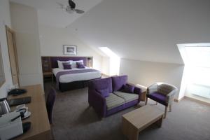 a hotel room with a bed and a couch at Weald of Kent Golf Course and Hotel in Maidstone