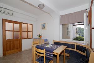 a dining room with a table and chairs and a window at Apartments Petra in Dubrovnik