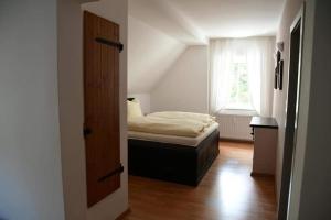 um pequeno quarto com uma cama e uma janela em Hotel Berggasthof Waldlust em Wunsiedel