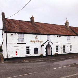 ein weißes Gebäude an der Straßenseite in der Unterkunft The George & Dragon in Felton