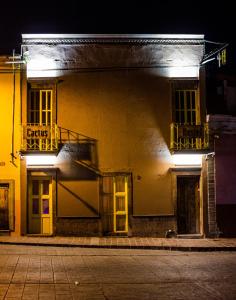 ein Gebäude mit gelben Türen und Fenstern in der Nacht in der Unterkunft Cactus Hostel & Suites in Guanajuato