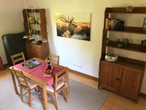 ein Esszimmer mit einem Tisch und einem Hirschbild an der Wand in der Unterkunft Ferienhaus Am Keschtebaum in Sasbachwalden