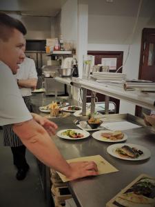 a man preparing food in a kitchen at Weald of Kent Golf Course and Hotel in Headcorn