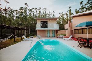 a villa with a swimming pool and a house at RECANTO DA SERRA in Mauá da Serra