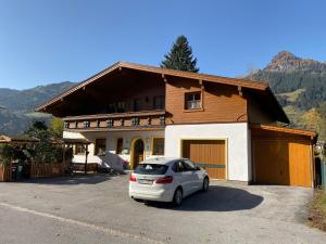 a white car parked in front of a house at Appartement Brandner in Bad Hofgastein