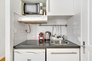 a small kitchen with a sink and a microwave at Pick A Flat's Apartments in Batignolles - Rue Biot in Paris