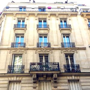 ein hohes Gebäude mit Balkon an der Seite in der Unterkunft L'appartement Magdebourg in Paris