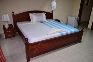 a bed with a wooden frame in a room at Musanto Hotel in Gisenyi