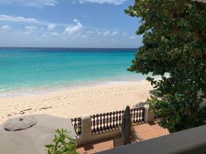 a view of a beach with a table and an umbrella at Beach Vue Barbados in Bridgetown