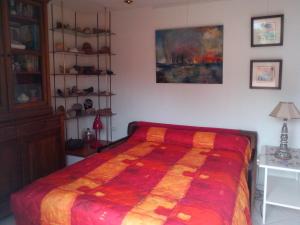 um quarto com uma cama com um edredão colorido em Chambres d'hôtes Issy-Paris em Issy-les-Moulineaux