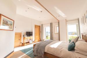
a bedroom with a large bed and a large window at Coed y Berclas guest room, wonderful view in Llandegfan
