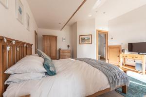 
a bedroom with a bed and a dresser at Coed y Berclas guest room, wonderful view in Llandegfan
