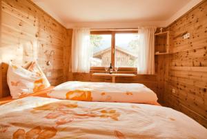 Schlafzimmer mit einem Bett und einem Fenster in der Unterkunft Lehrnerhof Lüsen in Lüsen
