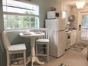 a kitchen with a small table and a refrigerator at Coastal Studio Escape! in Naples