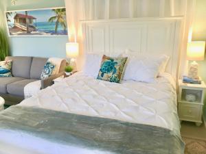 a large white bed in a room with a couch at Coastal Studio Escape! in Naples
