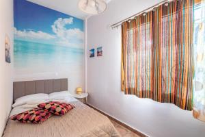 a bedroom with a bed with a large window at Cosy apartment in Stoupa in Stoupa
