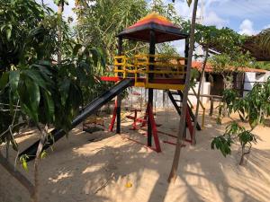a playground in the sand next to a tree at Chacara do Alemao in Flecheiras