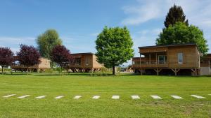 a large yard with a house in the background at Camping du Staedly in Roeschwoog
