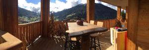 a table on a balcony with a view of a mountain at L’énergie Tranquillisante in Le Grand-Bornand