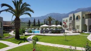 ein Resort mit einer Palme und einem Pool in der Unterkunft Vardis Olive Garden in Georgioupoli