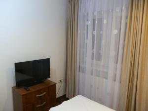 a bedroom with a television on a dresser next to a window at Garsoniera Strada Bucegi in Sibiu