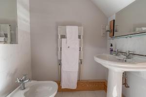 a white bathroom with a sink and a toilet at Coed y Berclas guest room, wonderful view in Llandegfan