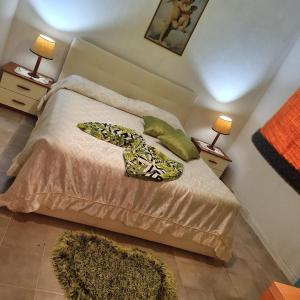 a bedroom with a bed with two lamps and two rugs at Casa di Giusy in Villa Santa Maria