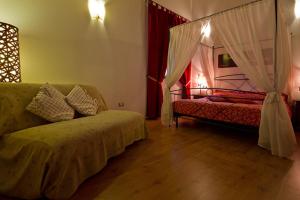 ein Wohnzimmer mit einem Sofa und einem Himmelbett in der Unterkunft Mulino Baiar in Stregna