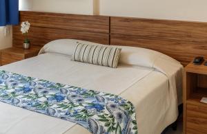 um quarto com uma cama e uma cabeceira em madeira em Rede Andrade Riviera Premium em Salvador