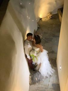 a bride and groom kissing in a tunnel at Villa Manos Hotel in Karterados