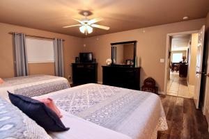 une chambre avec deux lits et un ventilateur de plafond dans l'établissement Poolside Porch Paradise, à New Braunfels 19 autres photos