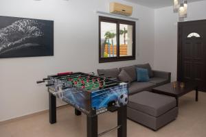 sala de estar con futbolín y sofá en Villa Fortuna, en Ayia Napa