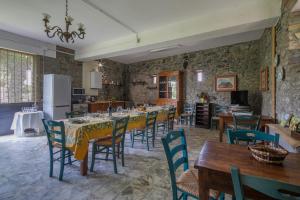 a dining room with tables and chairs and a kitchen at Il Gelso in Cortona