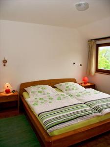 ein Bett in einem Schlafzimmer mit 2 Tischen und einem Fenster in der Unterkunft Gästehaus Schrot in Bad Schandau