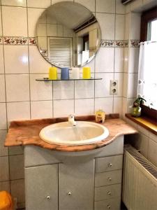 ein Bad mit einem Waschbecken und einem Spiegel in der Unterkunft Gästehaus Schrot in Bad Schandau