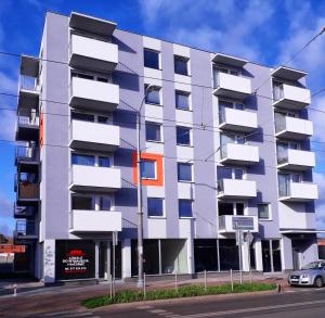 a white building with an orange window on a street at Apartament Yooka in Szczecin