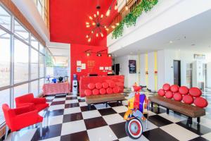 un vestíbulo con una habitación con muebles de color rojo y un scooter en Pop Art Hotel Tocancipá y Centro de Convenciones, en Tocancipá