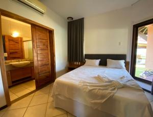 a bedroom with a bed with a sink and a mirror at Dream Beach Cumbuco Oceanfront Apartments in Cumbuco