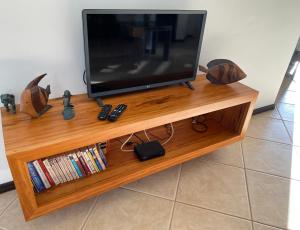 a flat screen tv sitting on a wooden entertainment center at Dream Beach Cumbuco Oceanfront Apartments in Cumbuco