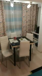 a dining room with a table and white chairs at ally apartament in Constanţa