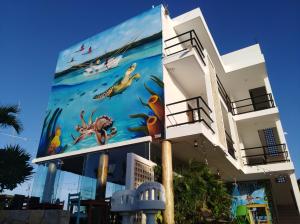 un bâtiment avec une fresque sur son côté dans l'établissement Yuum Ha Boutique Hotel, à Río Lagartos