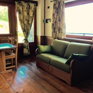 a living room with a couch and two windows at Chalet D'Antan in Pila