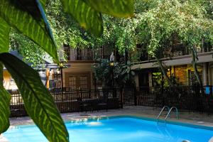 a swimming pool in front of a building with trees at Heritage Inn in Great Falls