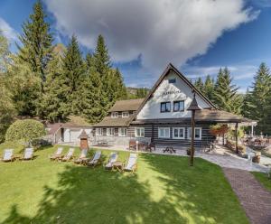 eine Gruppe von Stühlen auf einem Rasen vor einem Haus in der Unterkunft Hotel Resort Martin & Kristyna in Špindlerův Mlýn