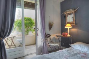 1 dormitorio con 1 cama y puerta corredera de cristal en Cottage Prairie Bonheur, en Magny-les-Hameaux